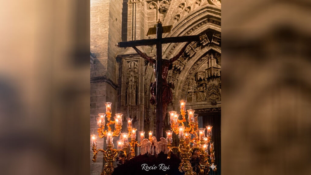 Paso de una hermandad del Domingo de Ramos 2026 por el centro de Sevilla con calles llenas de público
