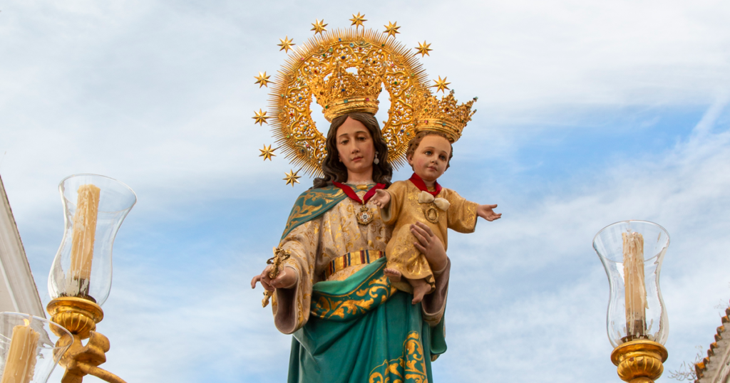 María Auxiliadora durante su salida procesional por las calles de Carmona acompañada por numerosos fieles y devotos.