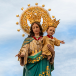 María Auxiliadora durante su salida procesional por las calles de Carmona acompañada por numerosos fieles y devotos.