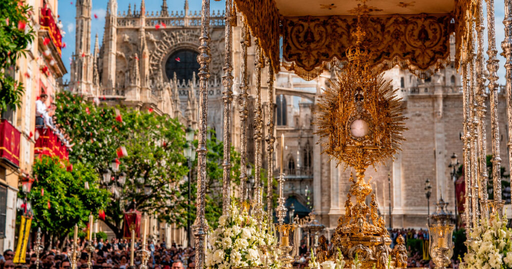 Procesión del Corpus Christi por las calles de Sevilla con el Santísimo Sacramento bajo palio.