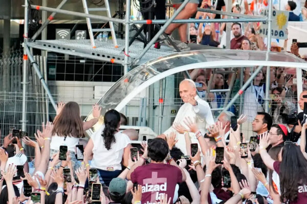 Multitud de fieles recibe al Papa durante un acto público en España con banderas españolas y vaticanas