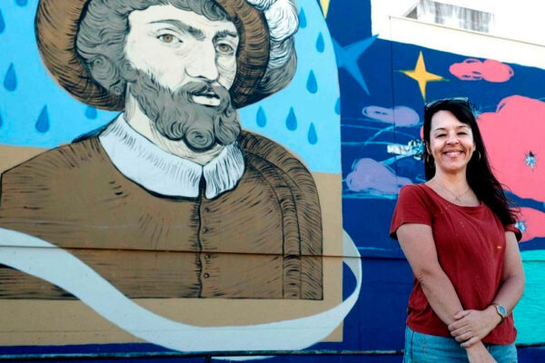 Ana Langeheldt junto a uno de sus murales, cartelista de las Fiestas de la Primavera de Sevilla 2027